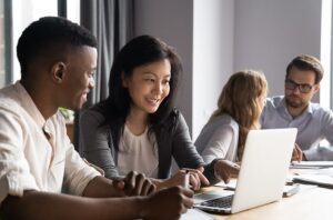 Two pairs of diverse men and women having cooperative work conversations